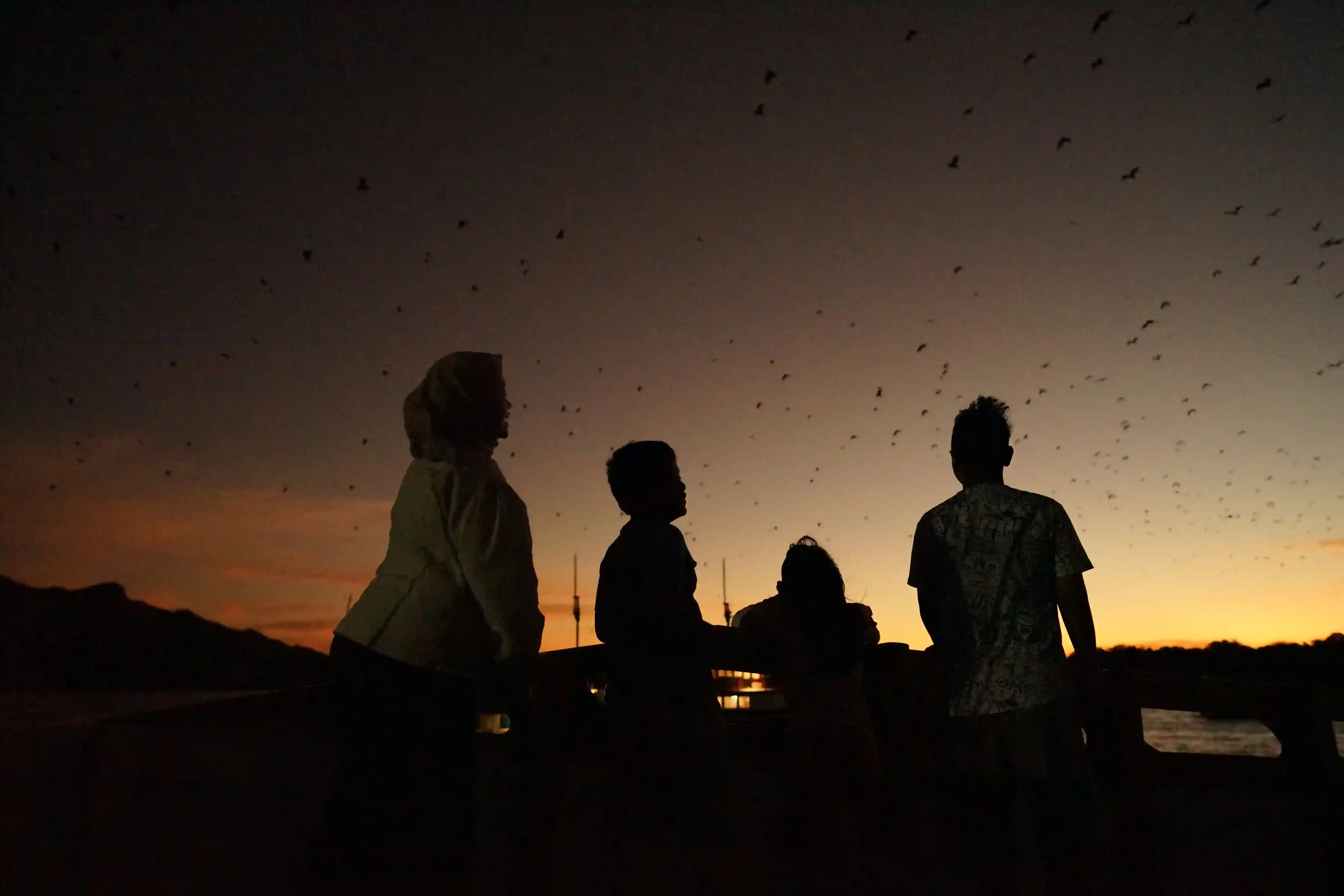 Family watching sunset at Kalong Island from the deck